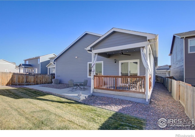 back of house featuring a lawn, ceiling fan, central AC unit, and a patio