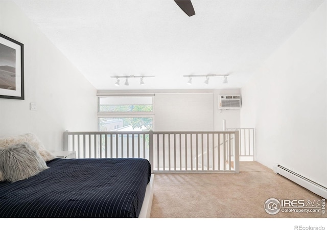 bedroom with baseboard heating, a wall mounted AC, light carpet, and track lighting