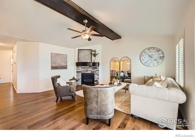 living room featuring hardwood / wood-style floors, vaulted ceiling with beams, a stone fireplace, and ceiling fan