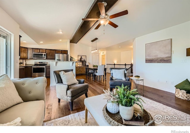 living room with lofted ceiling with beams, light hardwood / wood-style flooring, and ceiling fan