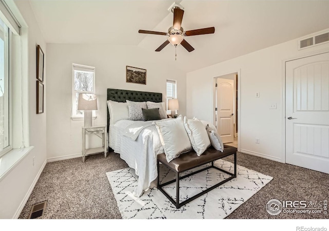 bedroom featuring carpet, vaulted ceiling, multiple windows, and ceiling fan