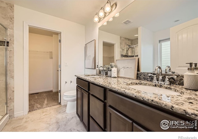 bathroom featuring vanity, an enclosed shower, and toilet