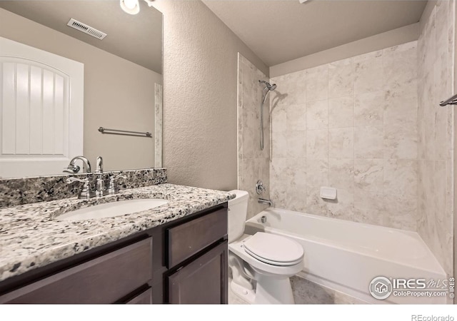 full bathroom with vanity, tiled shower / bath combo, and toilet