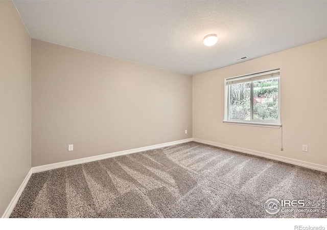 carpeted spare room with a textured ceiling