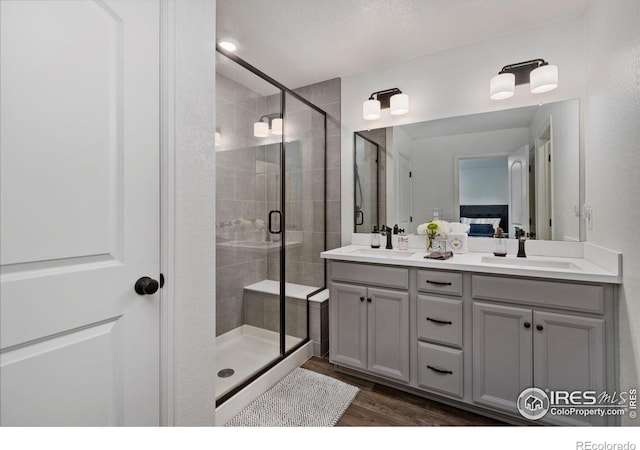 3583 Booth Falls Dr, Loveland, CO 80538 - bathroom featuring a shower stall, wood finished floors, and double vanity