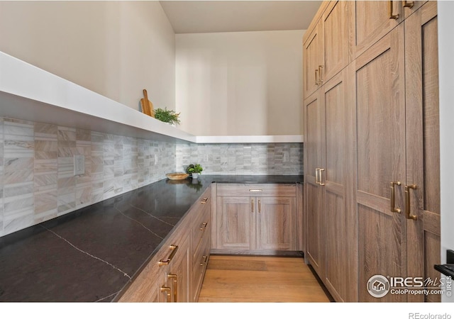 kitchen with decorative backsplash and light hardwood / wood-style floors