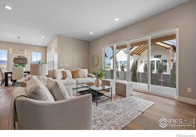 living room featuring an inviting chandelier and light hardwood / wood-style floors