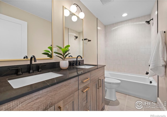 full bathroom featuring tile patterned floors, toilet, vanity, and tiled shower / bath combo