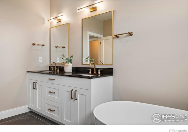 bathroom with vanity, tile patterned flooring, and a washtub