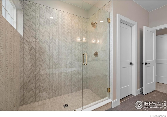 bathroom featuring tile patterned floors and a shower with shower door