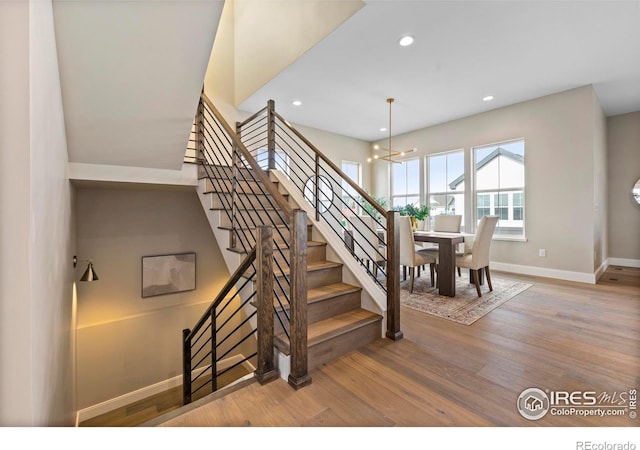 stairway featuring a notable chandelier and hardwood / wood-style floors