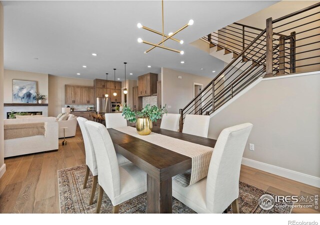 dining room with light hardwood / wood-style floors and a notable chandelier