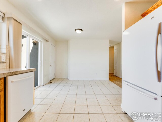 kitchen featuring white appliances and light tile patterned floors