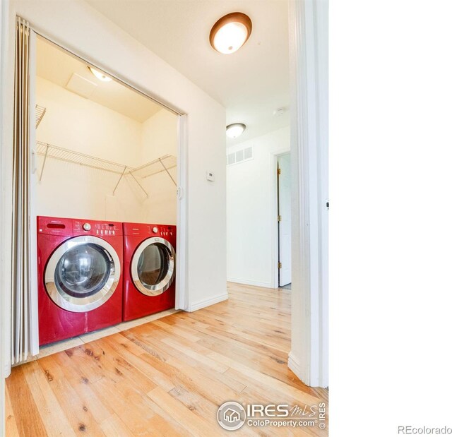 washroom with washing machine and dryer and hardwood / wood-style floors