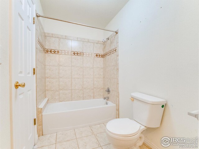 bathroom featuring tile patterned flooring, tiled shower / bath, and toilet