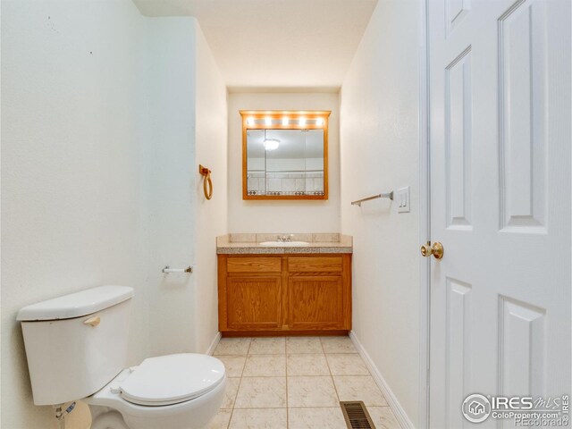 bathroom with tile patterned flooring, vanity, and toilet