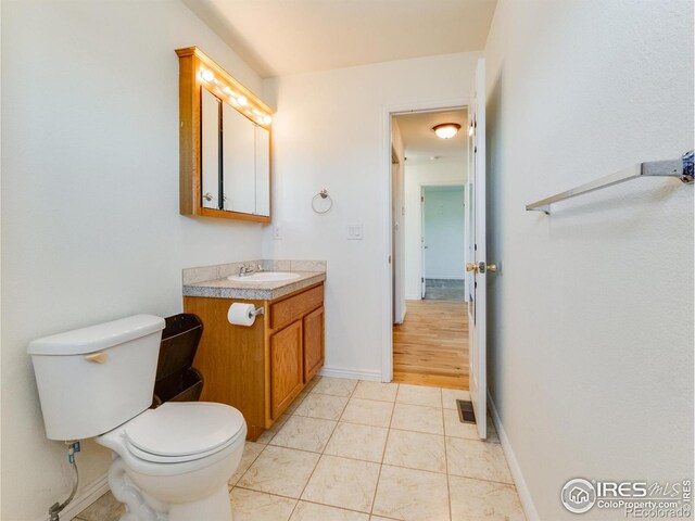 bathroom featuring toilet, vanity, and tile patterned floors