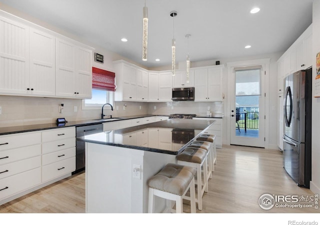 kitchen featuring hanging light fixtures, a center island, a healthy amount of sunlight, and appliances with stainless steel finishes