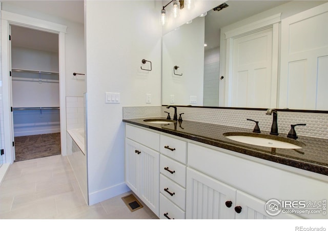 bathroom with tile patterned floors, vanity, and tasteful backsplash