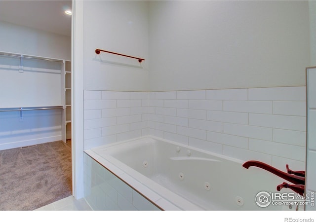 bathroom with a relaxing tiled tub