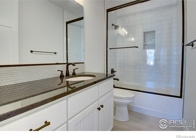 full bathroom featuring shower / bath combination with glass door, vanity, toilet, and tile patterned flooring