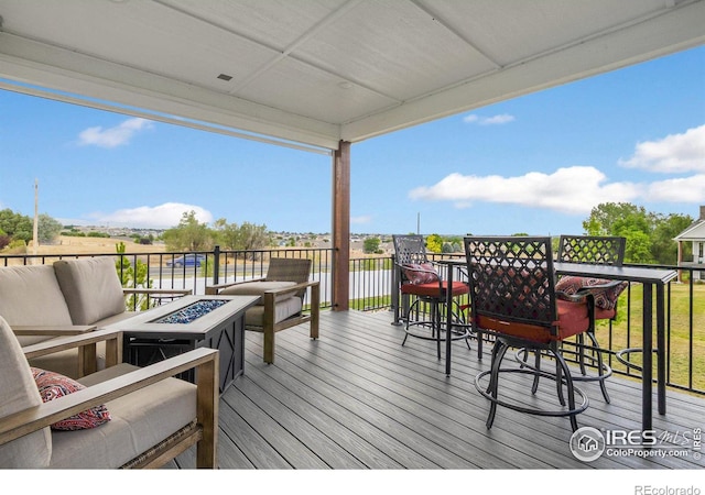 deck featuring an outdoor living space with a fire pit