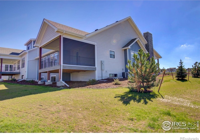 view of property exterior with a sunroom and a yard