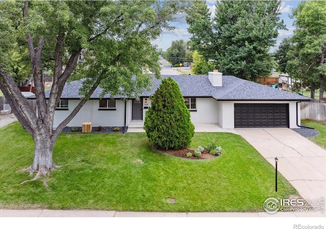 view of front of property featuring a garage and a front lawn