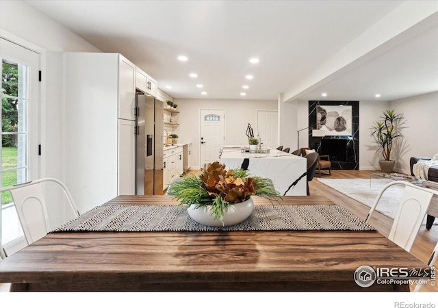 dining room featuring light hardwood / wood-style flooring and a premium fireplace