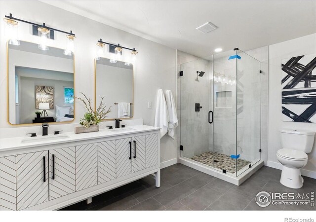 bathroom with tile patterned flooring, vanity, an enclosed shower, and toilet