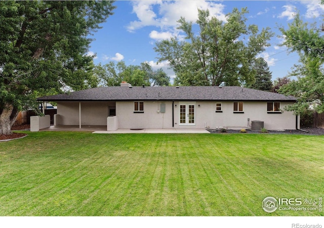 back of property with central AC unit, a patio, a lawn, and french doors