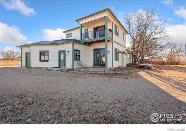 rear view of house with a balcony and a patio