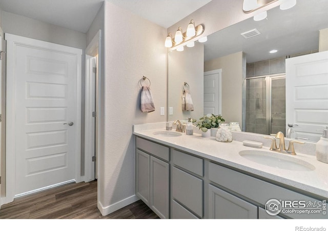 bathroom with vanity, hardwood / wood-style flooring, and a shower with door