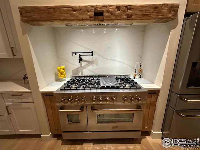 kitchen featuring tasteful backsplash, stainless steel appliances, and light wood-type flooring