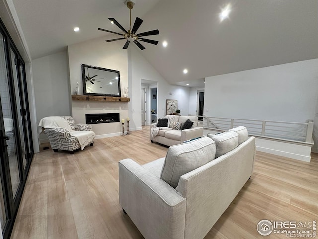 living room with high vaulted ceiling, ceiling fan, a fireplace, and light hardwood / wood-style flooring