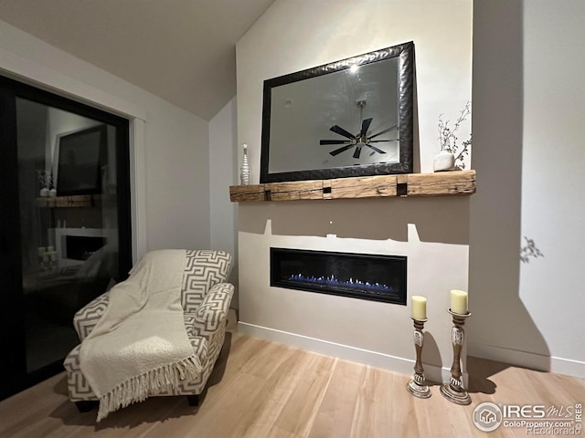 sitting room featuring vaulted ceiling and hardwood / wood-style floors