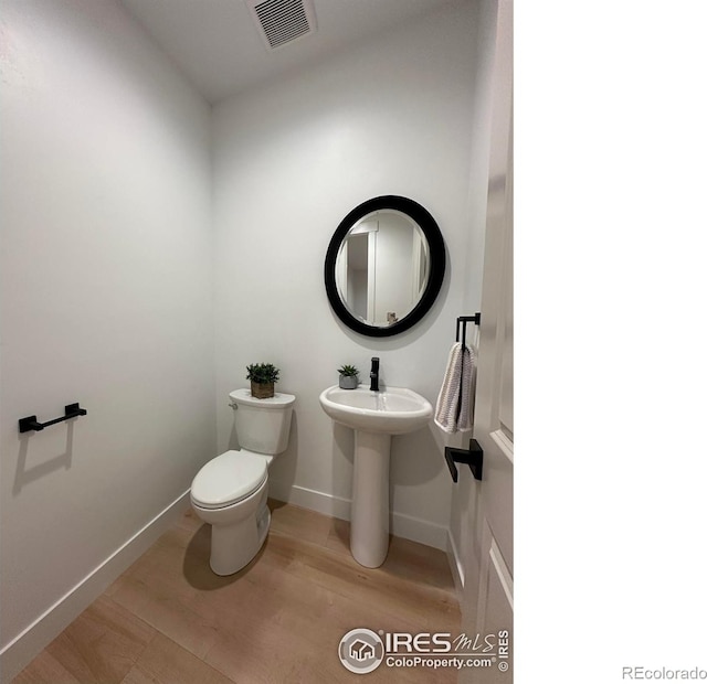 bathroom with hardwood / wood-style floors and toilet