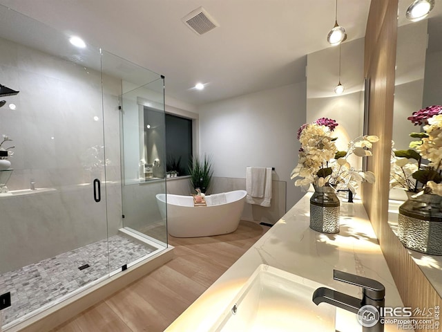 bathroom with shower with separate bathtub and hardwood / wood-style floors