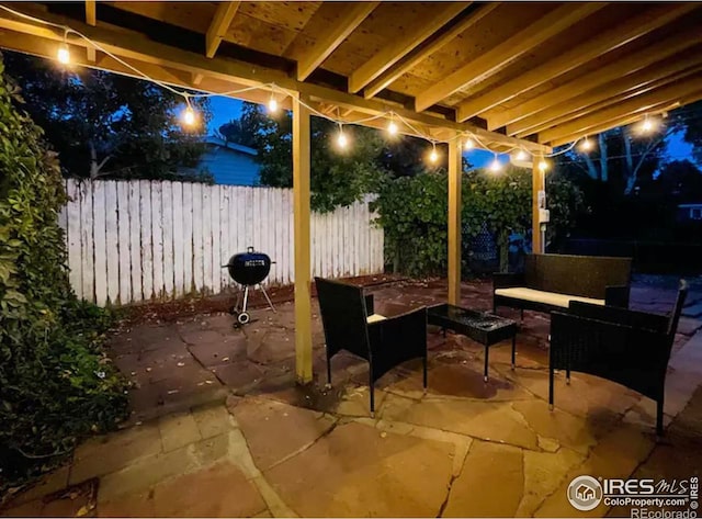 patio at twilight featuring grilling area and an outdoor hangout area