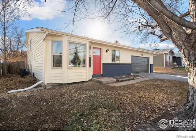 view of front of property with a garage and central air condition unit