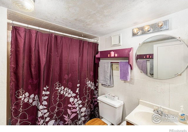 bathroom featuring vanity, a textured ceiling, and toilet