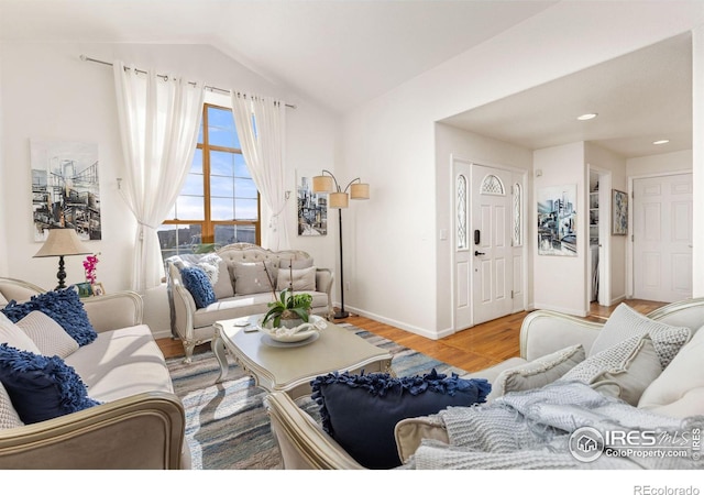 living room featuring vaulted ceiling and hardwood / wood-style flooring