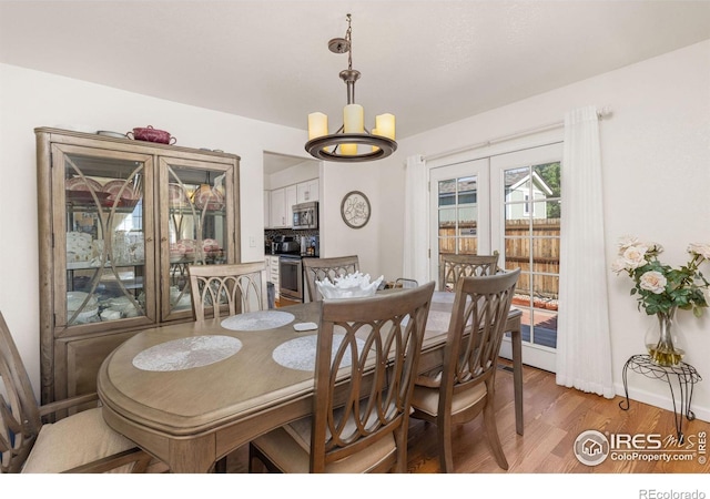 dining space with a notable chandelier, dark hardwood / wood-style flooring, and french doors