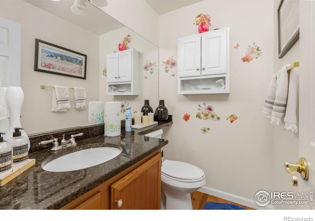 bathroom featuring hardwood / wood-style floors, vanity, and toilet