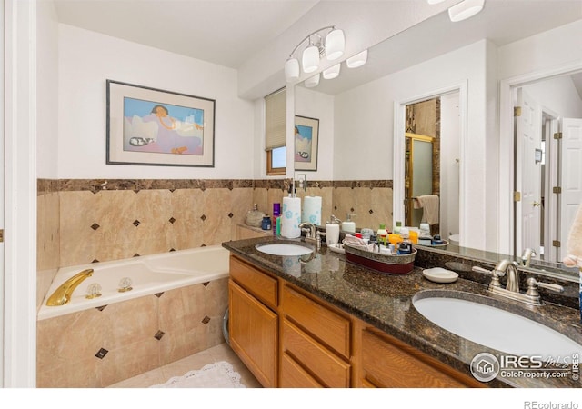 bathroom featuring vanity, a relaxing tiled tub, and tile patterned floors