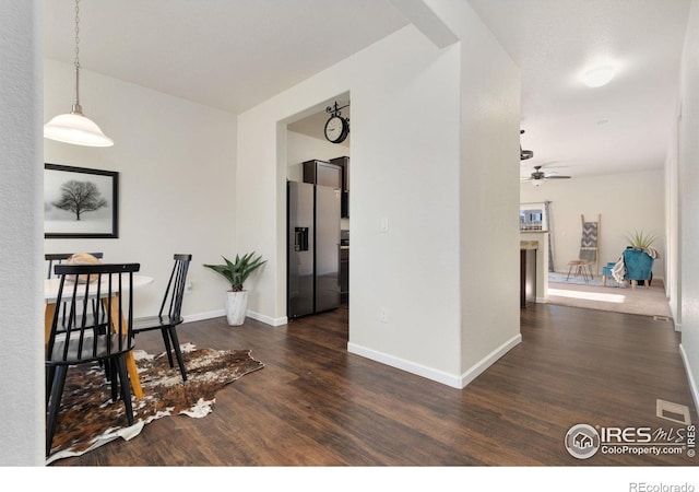 dining space with ceiling fan and dark wood-type flooring