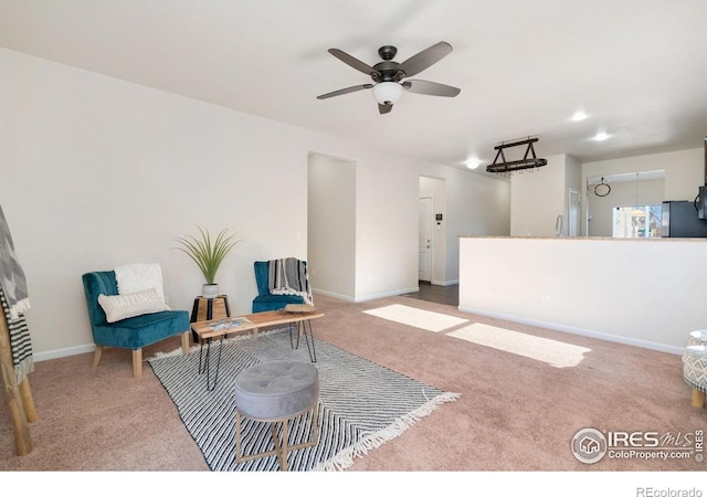 living area featuring light carpet and ceiling fan