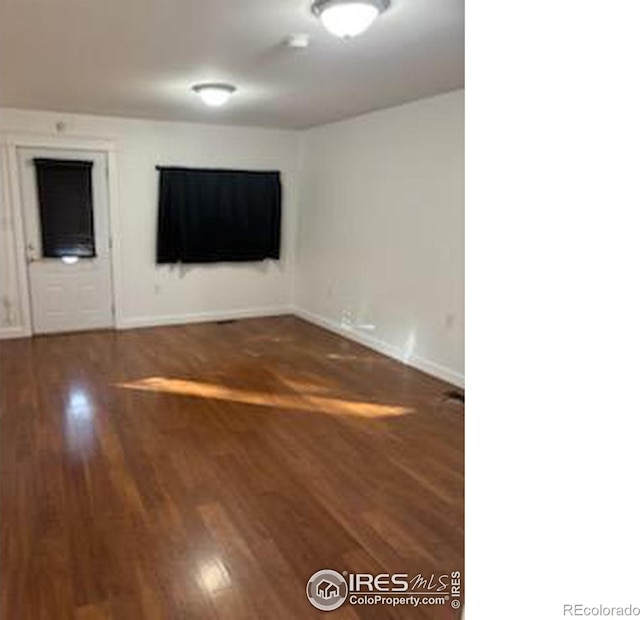 spare room featuring dark wood-type flooring