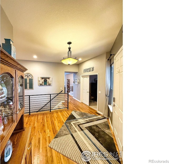 corridor featuring a textured ceiling and hardwood / wood-style flooring