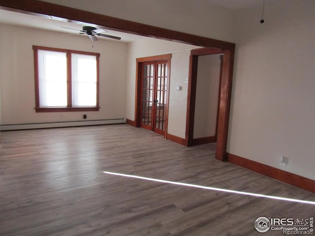 spare room with ceiling fan, hardwood / wood-style floors, and a baseboard heating unit